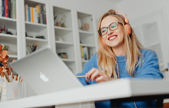 Woman running online class on laptop wearing headphones