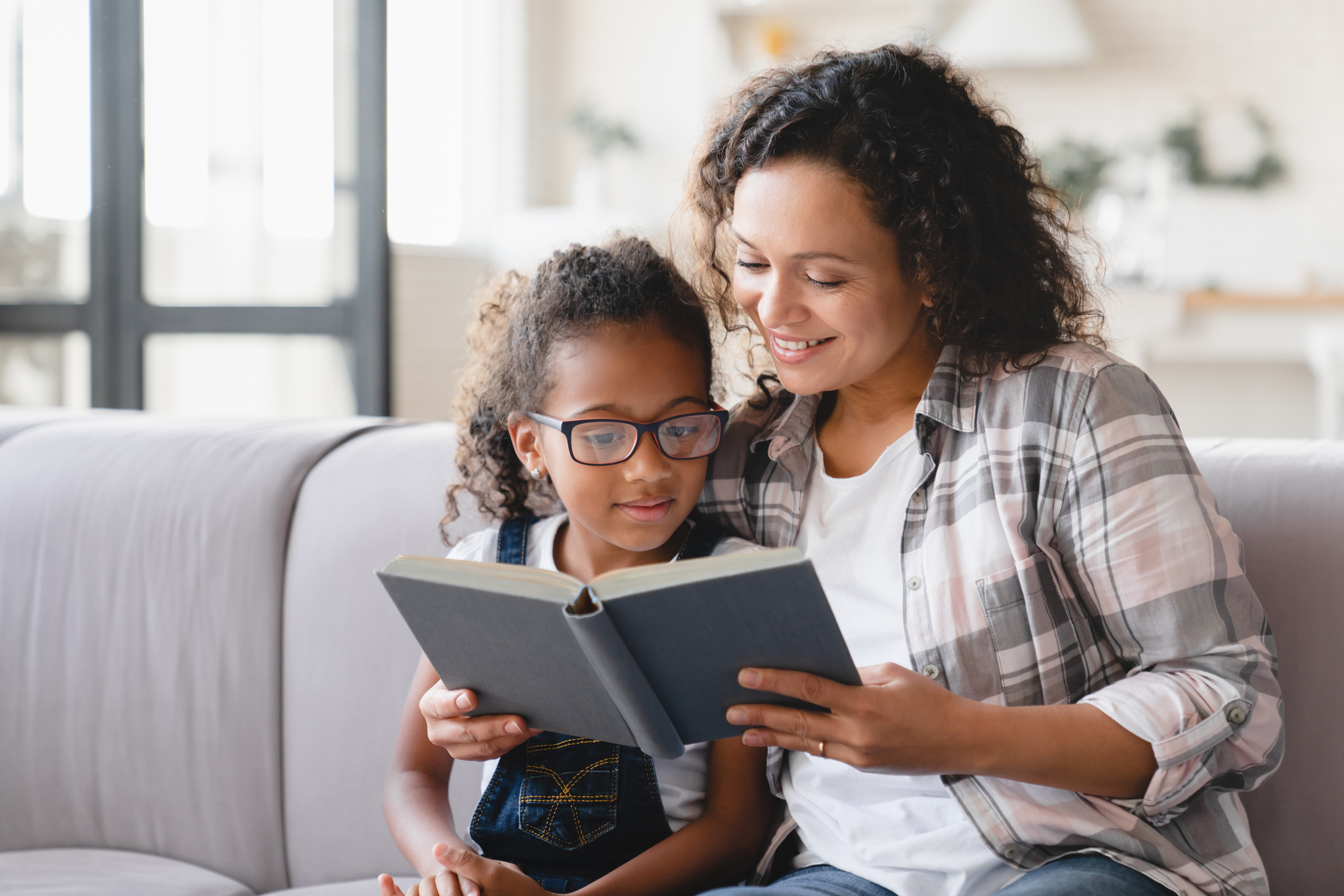 Home schooling mother reading with daughter