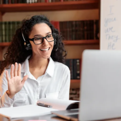 woman in front of a computer waving